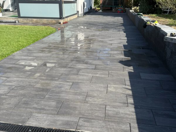 Plattenfläche mit Entwässerungsrinne und Rasen in Köln-Longerich