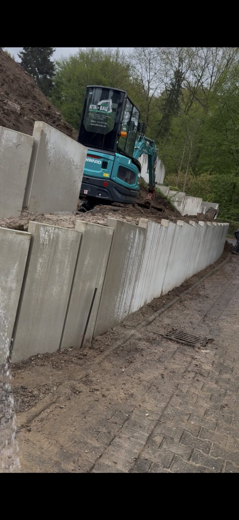 L-Steine werden mit dem Bagger gesetzt